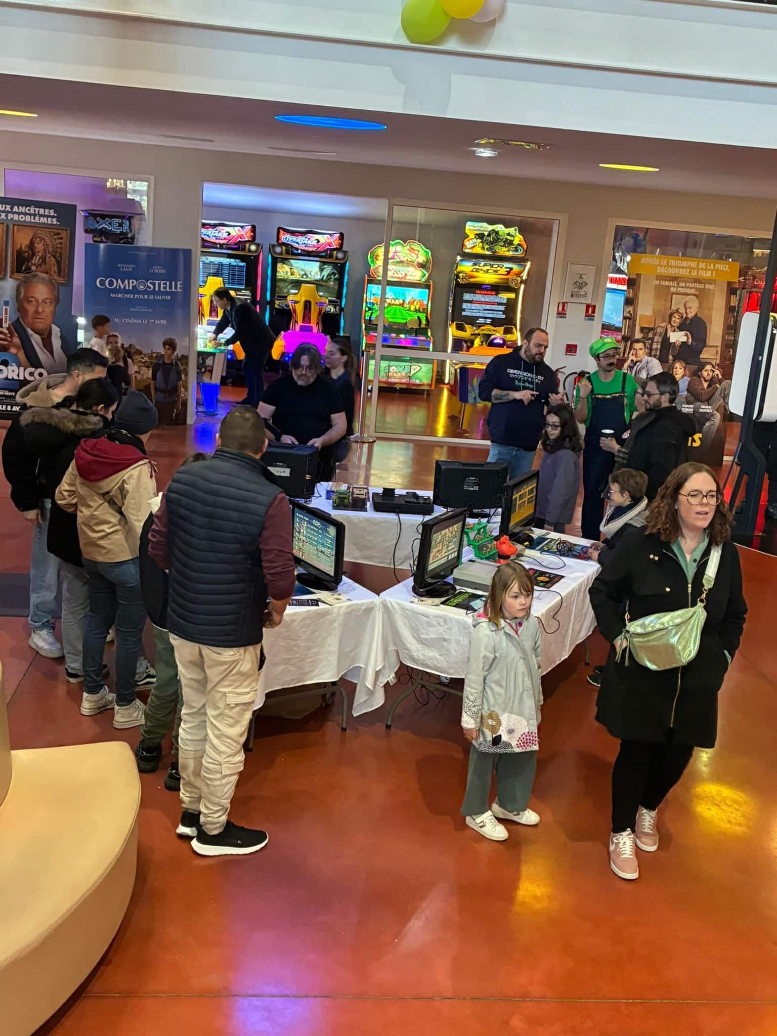 Animation événementielle Le P'tit Comité : stand rétro gaming avec bornes d'arcade en arrière-plan, public familial